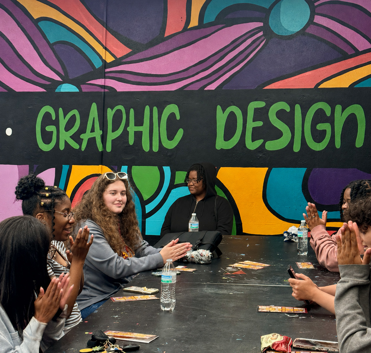 Graphic Design students at ULM are seated at a black table.