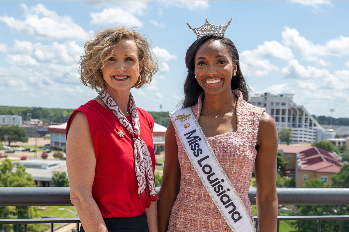 President Castille and Miss Louisiana Gabrelle McLeod posing on library terrace with the ULM campus in the background. 