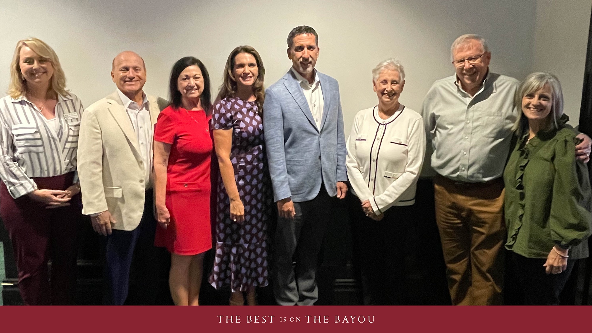 Group of people standing in a row and smiling.