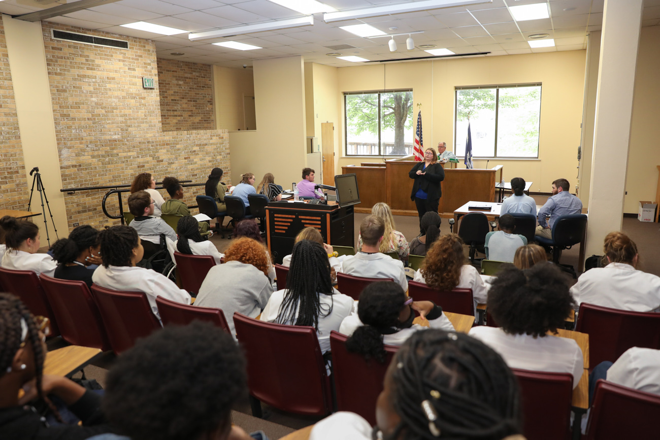 A group of people gather in the ULM E. Orum Young Mock Trial Courtroom