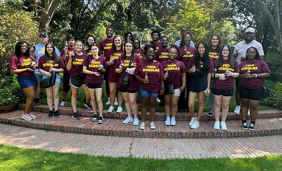 trio scholars group outside on green grass
