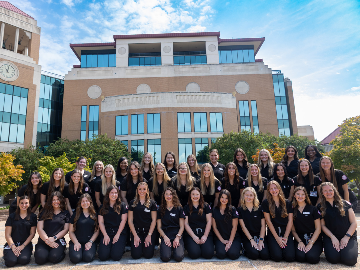 SLP students in a group, smiling in front of Library on the plaza