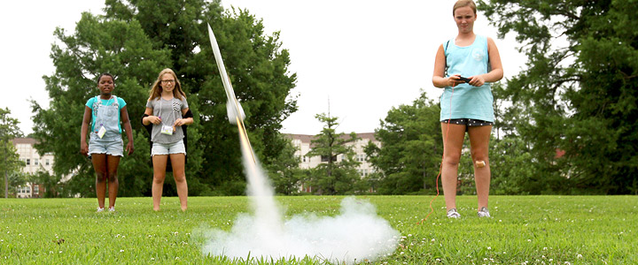 girls at camp launching a rocket